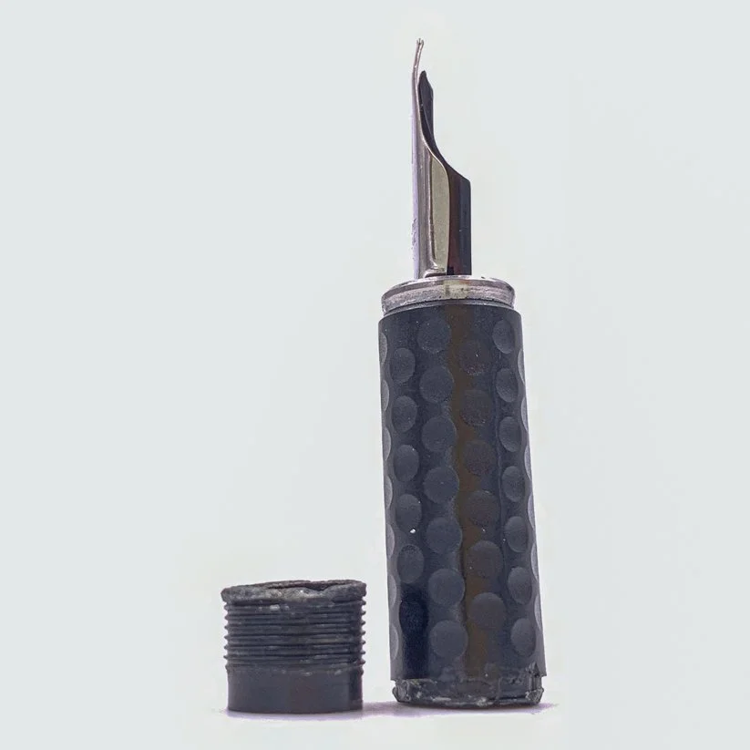 Broken thread positioned next to grip section and nib